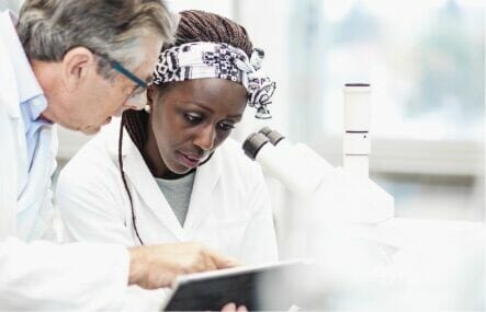 Two people in a lab looking at a tablet
